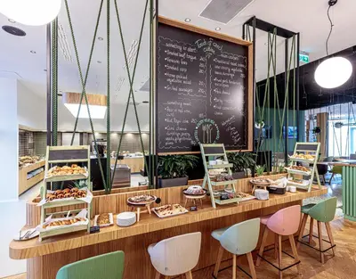 a restaurant with a counter with a chalkboard at Holiday Inn Prague by IHG in Prague