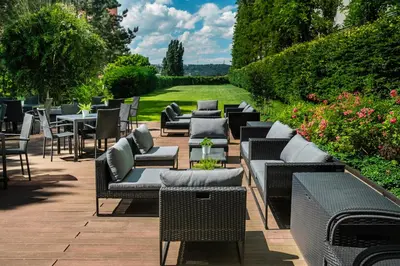 a row of chairs and tables and chairs on a patio at Holiday Inn Prague by IHG in Prague
