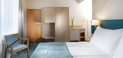 a hotel room with a bed and a chair at Holiday Inn Prague by IHG in Prague