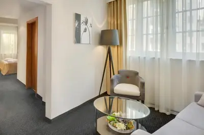 a living room with a chair and a table at Hotel Clement in Prague