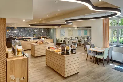 a restaurant with tables and chairs and a cafeteria at Hotel Clement in Prague