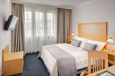 a hotel room with a bed and a desk at Hotel Clement in Prague