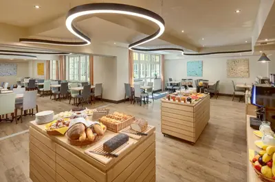 a lobby with a cafeteria with tables and chairs at Hotel Clement in Prague