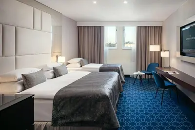 a hotel room with two beds and a flat screen tv at Hotel KINGS COURT in Prague