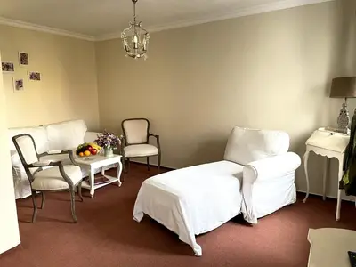 a room with white furniture and a table and chairs at Amálka u Řípu in Straškov