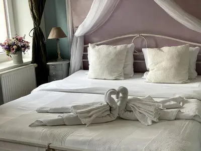 two swans are sitting on a white bed at Amálka u Řípu in Straškov