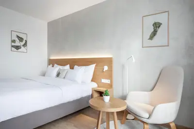 a bedroom with a bed and a chair and a table at Botanique Hotel Prague in Prague