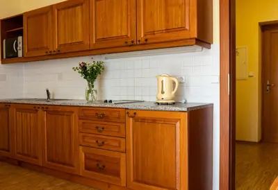 a kitchen with wooden cabinets and a vase of flowers at Pavilon in Ricany