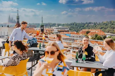 a group of people sitting at tables on a roof at Metropolitan Old Town Hotel - Czech Leading Hotels in Prague