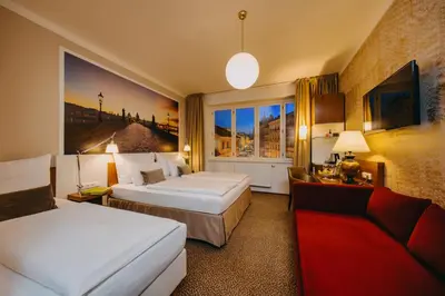 a hotel room with two beds and a couch at Metropolitan Old Town Hotel - Czech Leading Hotels in Prague