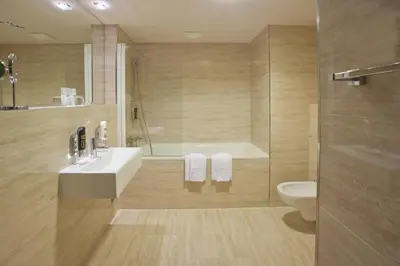 a bathroom with a sink and a tub and a toilet at Grand Majestic Hotel Prague in Prague