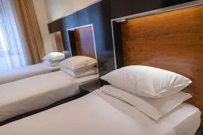 a bedroom with two beds with pillows and a mirror at Grand Majestic Hotel Prague in Prague