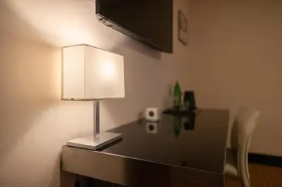 a desk with a lamp on it with a lamp at Grand Majestic Hotel Prague in Prague