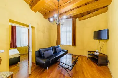 a living room with a black leather couch and a tv at Residence Seven Angels in Prague