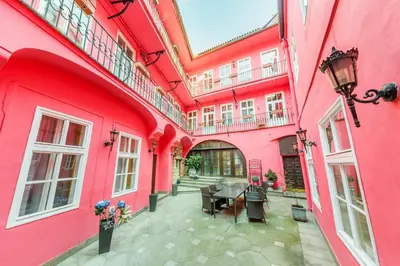 a pink building with a table in a courtyard at Residence Seven Angels in Prague