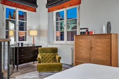 a bedroom with a bed and a chair and a desk at Augustine, a Luxury Collection Hotel, Prague in Prague