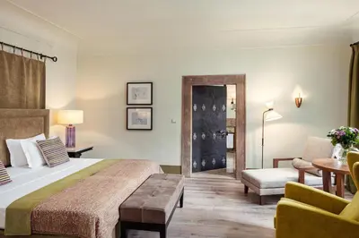 a hotel room with a bed and a chair at Augustine, a Luxury Collection Hotel, Prague in Prague