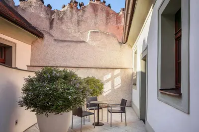 a patio with a table and chairs and a plant at Augustine, a Luxury Collection Hotel, Prague in Prague