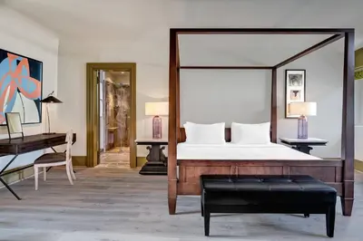 a bedroom with a large bed and a desk at Augustine, a Luxury Collection Hotel, Prague in Prague