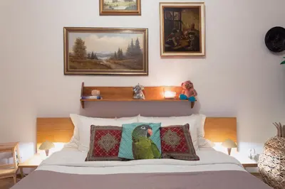 a bedroom with a bed with pillows and paintings at Victoria Design Stays - Apartment Rehorova in Prague