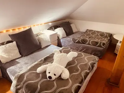 a bedroom with two beds with a teddy bear on the bed at Apartment Neratovice in Neratovice