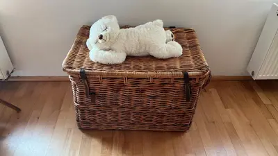 a teddy bear sitting on top of a wicker basket at Apartment Neratovice in Neratovice