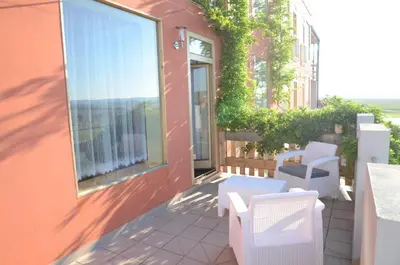 a balcony with chairs and a window on a building at Penzion Folbr in Dlouhá Lhota