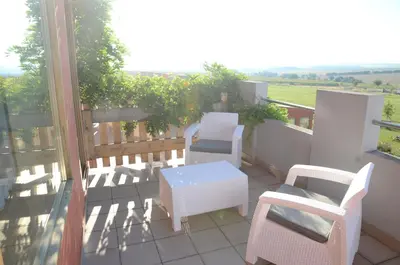a balcony with chairs and a table and a view at Penzion Folbr in Dlouhá Lhota