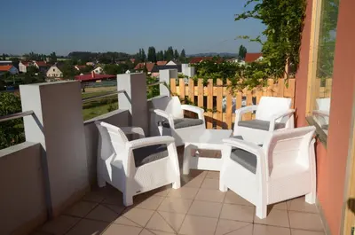a group of white chairs sitting on a balcony at Penzion Folbr in Dlouhá Lhota