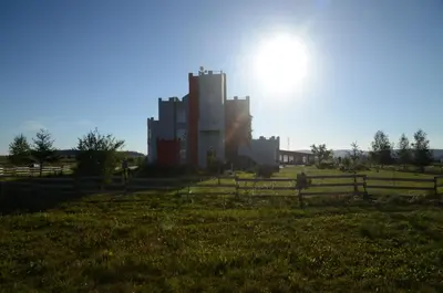 a large building in a field with a fence at Penzion Folbr in Dlouhá Lhota