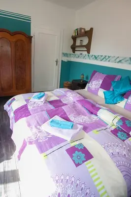 a bed with a purple and white quilt on it at Vila Sazava in Sázava