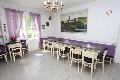a dining room with tables and chairs and a painting on the wall at Vila Sazava in Sázava