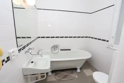 a white bathroom with a tub and a sink at Vila Sazava in Sázava