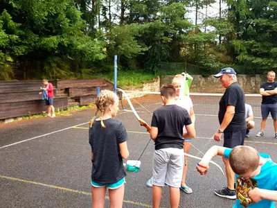 a group of children playing a game on a tennis court at Penzion Pod Houskou in Blatce