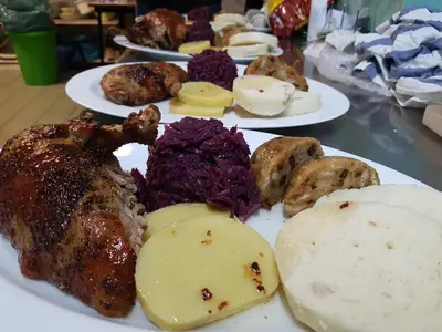 a plate of food with meat and vegetables on a table at Penzion Pod Houskou in Blatce