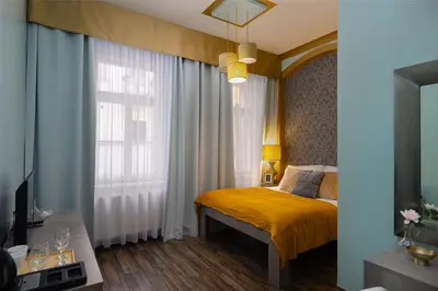 a bedroom with a yellow bed and a window at Salvatore Prague Rooms in Prague