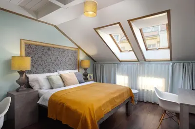 a bedroom with a large bed and two skylights at Salvatore Prague Rooms in Prague