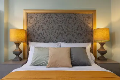 a bedroom with a large bed with two lamps at Salvatore Prague Rooms in Prague