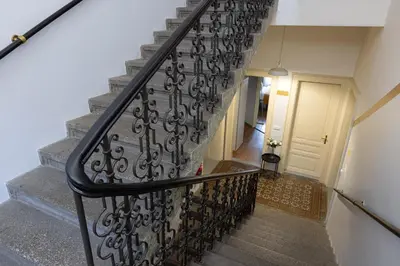 a stairway with a wrought iron railing and a door at Salvatore Prague Rooms in Prague