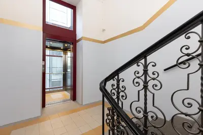 a hallway with a staircase and an open door at Salvatore Prague Rooms in Prague