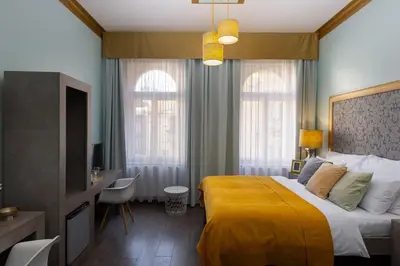 a bedroom with a bed with a yellow blanket at Salvatore Prague Rooms in Prague