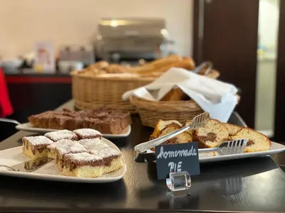 a table with three plates of bread and pastries at Red & Blue Design Hotel Prague in Prague