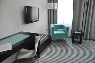 a hotel room with a desk and a tv and a chair at Red & Blue Design Hotel Prague in Prague