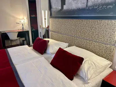 two beds with red pillows in a hotel room at Red & Blue Design Hotel Prague in Prague