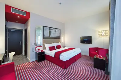 a hotel room with a red and white bed and a tv at Red & Blue Design Hotel Prague in Prague