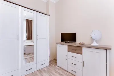 a white bedroom with a tv on a dresser at Apartment Masná 21 in Prague