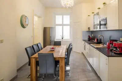 a kitchen and dining room with a wooden table and chairs at Masná - Old Town Residence in Prague