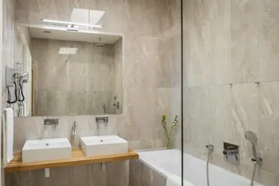 a bathroom with two sinks and a tub and a mirror at Masná - Old Town Residence in Prague