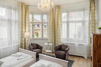 a bedroom with two chairs and a bed and a chandelier at Templova Old Town Apartment in Prague
