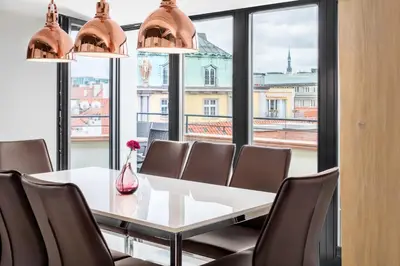 a dining room with a table and chairs and a large window at Templova Old Town Apartment in Prague